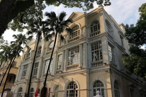 Um edifício de vários andares, com grandes janelas e estilo arquitetônico clássico.