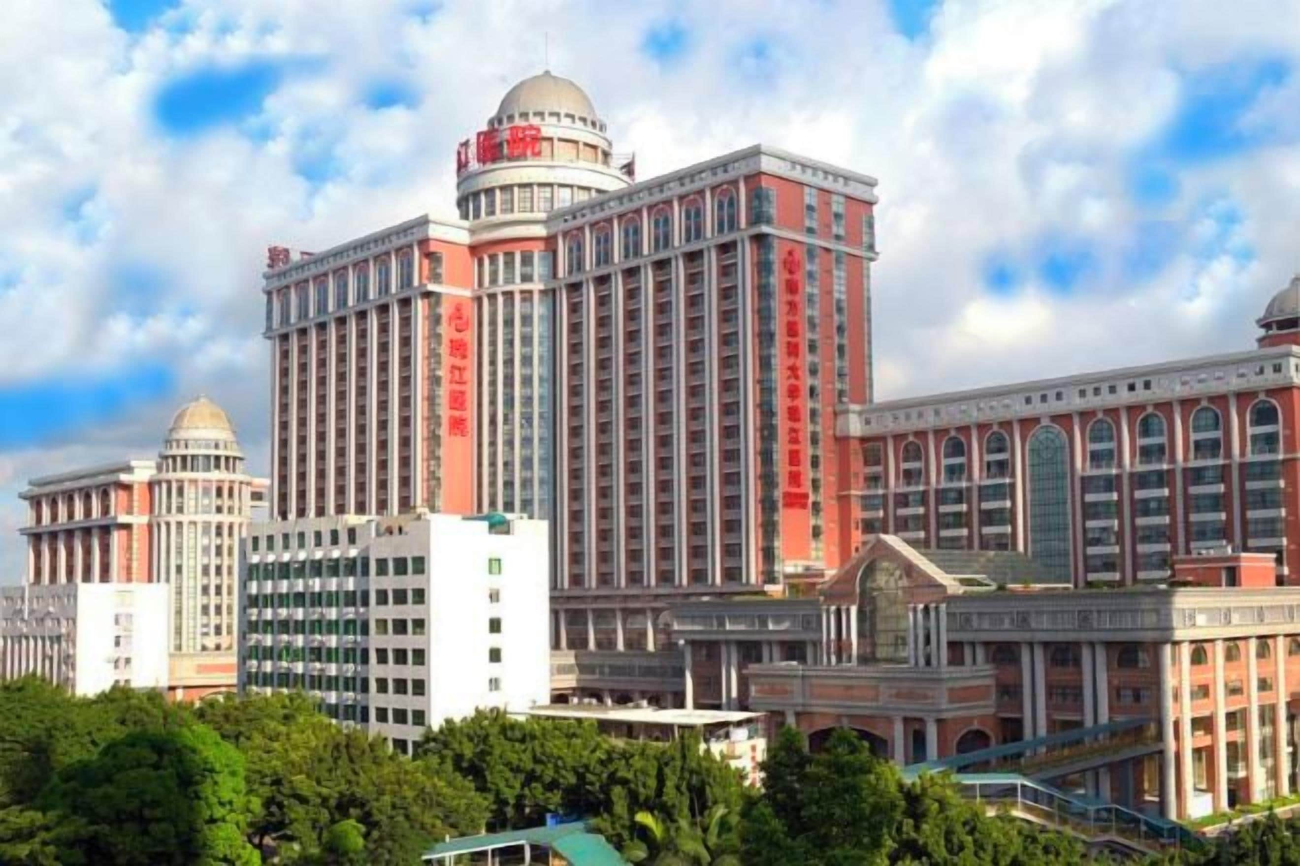 Un hotel de varios pisos con una fachada destacada en rojo y blanco, amplios ventanales y una estructura en forma de cúpula en la parte superior.