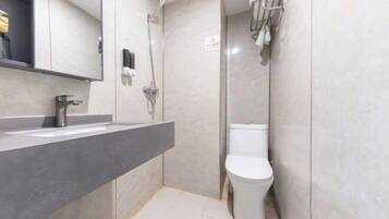 A modern bathroom with a grey sink, a toilet, and a shower.