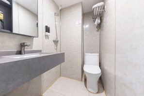 A modern bathroom with a grey sink, a toilet, and a shower.