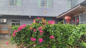 Un bâtiment à la façade en briques, une clôture en bois et une lanterne rouge.