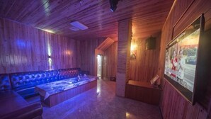 Un intérieur en bois avec une table de massage, un banc et une affiche au mur.