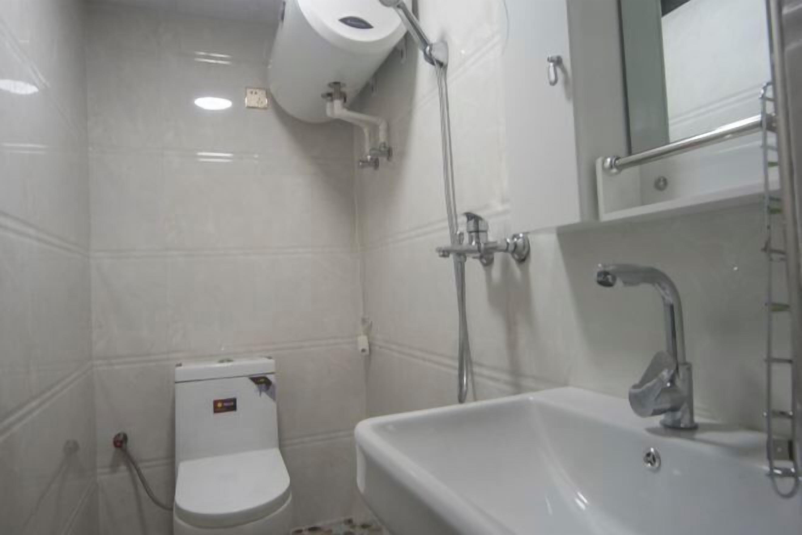 A bathroom with a toilet, sink, and shower.