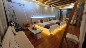Une chambre d’hôtel moderne avec un plafond en bois, deux lits, une petite table et une chaise.