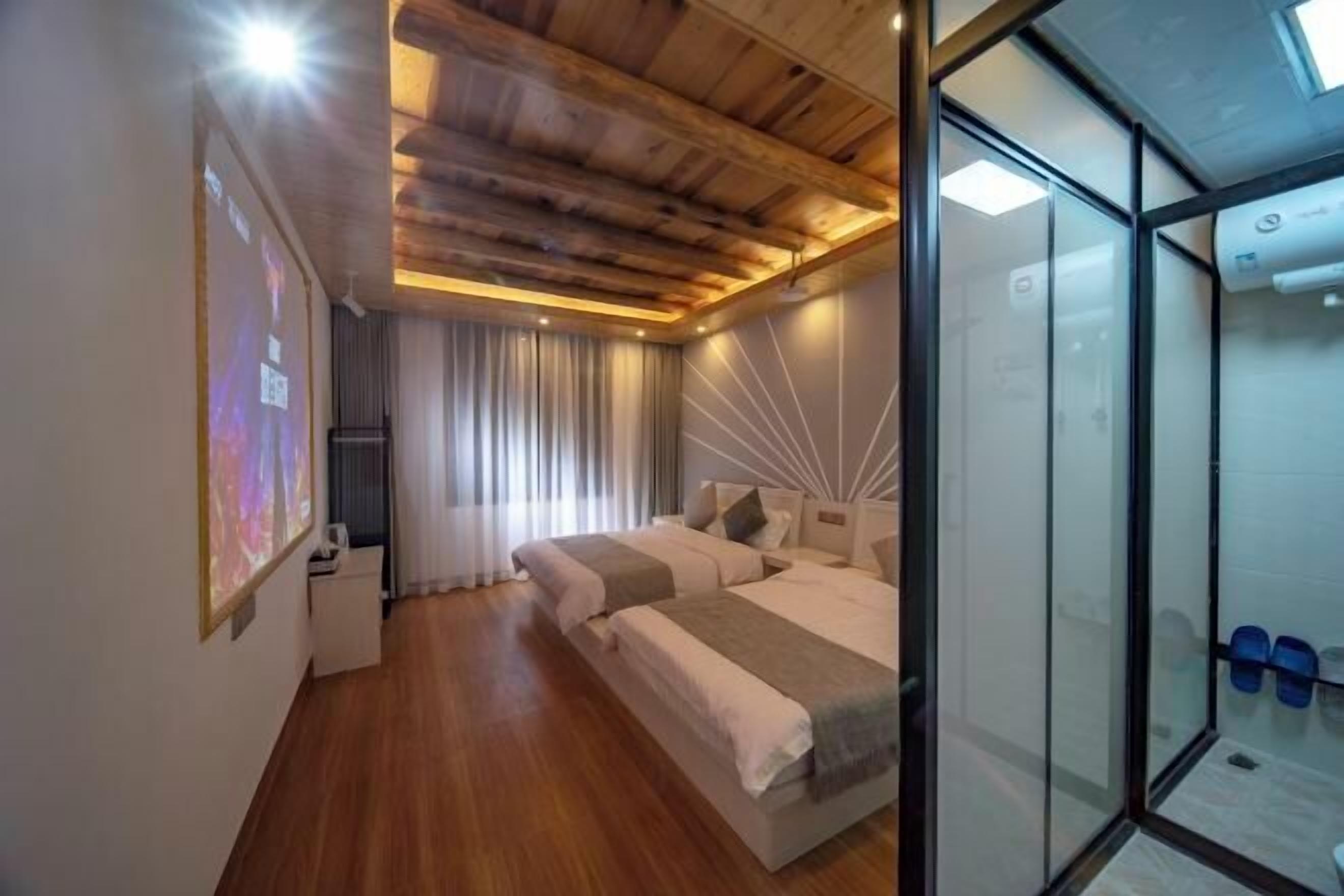 A modern bedroom with a wooden ceiling, a bed with white bedding, a bedside table, and a glass partition.