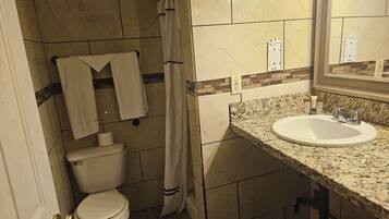 Un bagno con il water, il lavandino e una tenda da doccia.