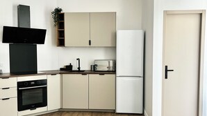 Een moderne keuken met een inbouwoven, een koelkast en een magnetron.