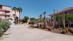 A pathway leading to a building with a garden featuring cacti and palm trees. - Villa Giulia (Syracuse)