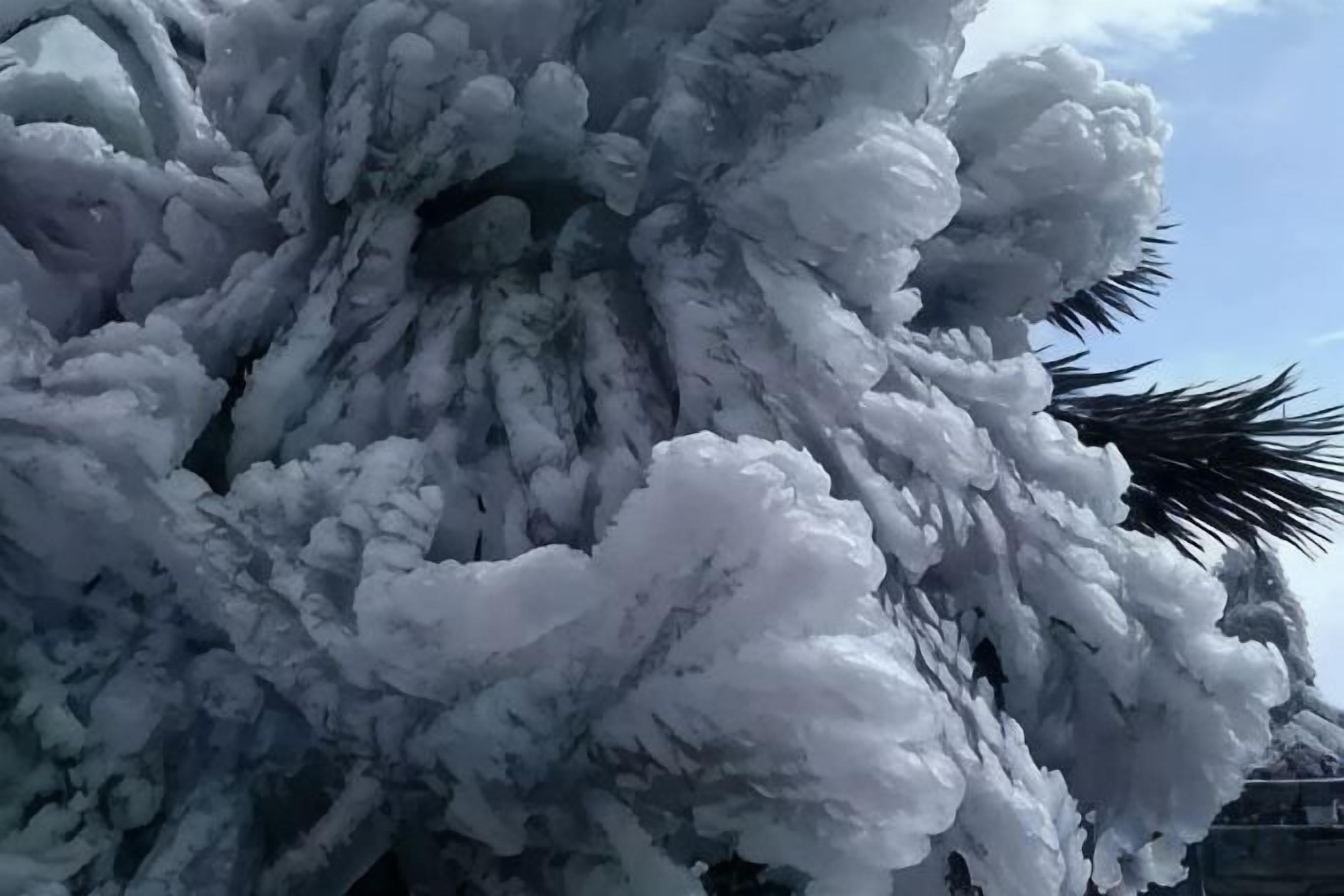A large, intricate ice sculpture with a complex structure and a palm tree silhouette.