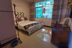 A bedroom with a bed, a desk, a chair, a window with curtains, and a wall-mounted telephone. - Hengyang Nanyueshan Xiangyuan Manor (Hengyang)