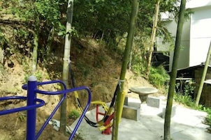 Un espacio al aire libre con equipo de ejercicio, un camino de hormigón y una pendiente.