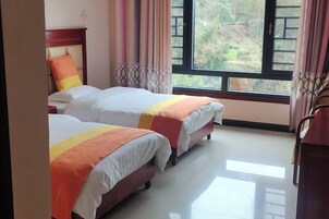Una habitación con dos camas, una ventana y cortinas.