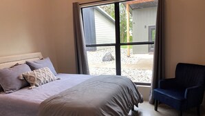 A bedroom with a bed, a chair, and a large window. - Cozy cottage in charming downtown Mount Vernon. (Mount Vernon)