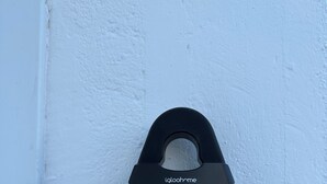 Un portero automático negro montado en una pared blanca.
