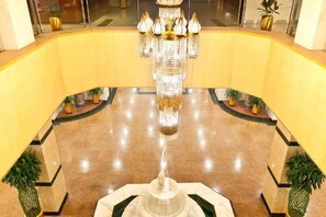 A lobby with a central chandelier, a fountain, and potted plants. - Yang Quan Hotel (Yangquan)