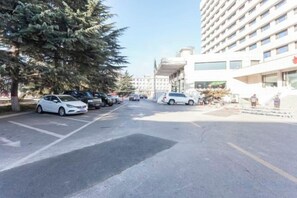 A parking lot with cars and a building with multiple floors and windows. - Yang Quan Hotel (Yangquan)