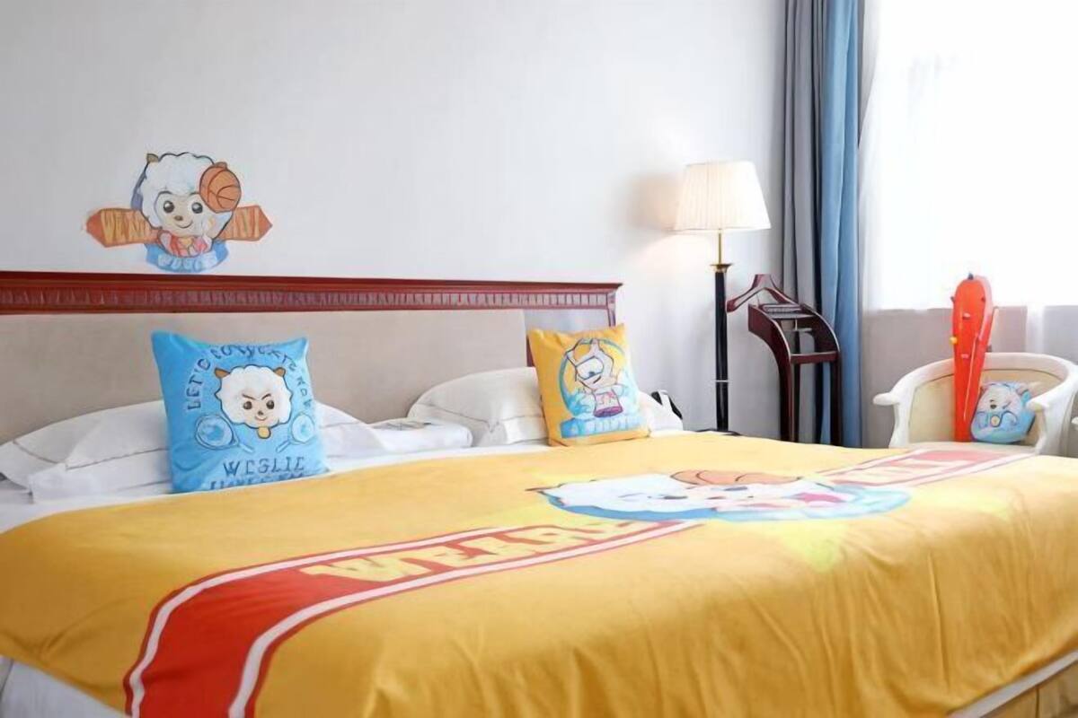 A hotel room with a bed, pillows, a lamp, and a chair.