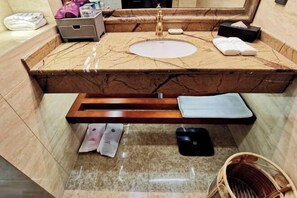 A bathroom with a marble sink, a towel rack, a shelf, and a basket. - Yang Quan Hotel (Yangquan)