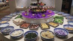 En buffé med olika rätter upplagda i skålar och på fat.