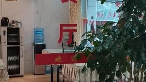 Un vestíbulo de hotel con una recepción, un dispensador de agua y una máquina de café.