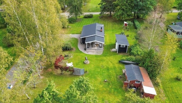A residential property with a main house, a detached garage, and a small shed.