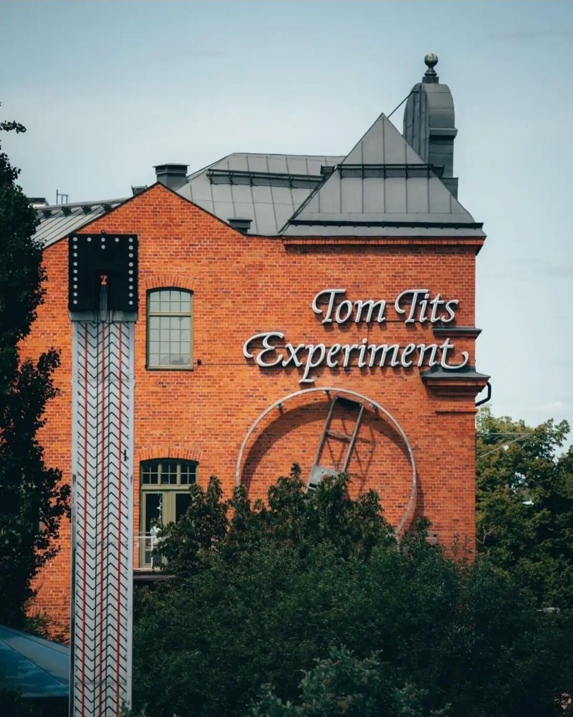 A brick building with a sign that reads "Tom Tits Experiment."