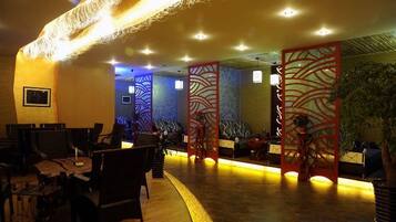 A restaurant with a curved counter, seating area, and decorative panels.
