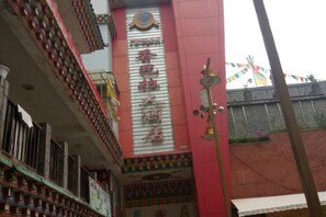 A hotel facade with a prominent sign, balconies, and decorative elements. - Xiangbala Hotel (Muli)