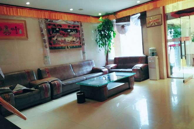A spacious living room with a sofa set, a coffee table, and a large window providing natural light.