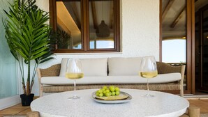 A round table with a white speckled top, two wine glasses, a plate of grapes, and a potted plant. - A021 - COLINA DEL SOL (Calpe)