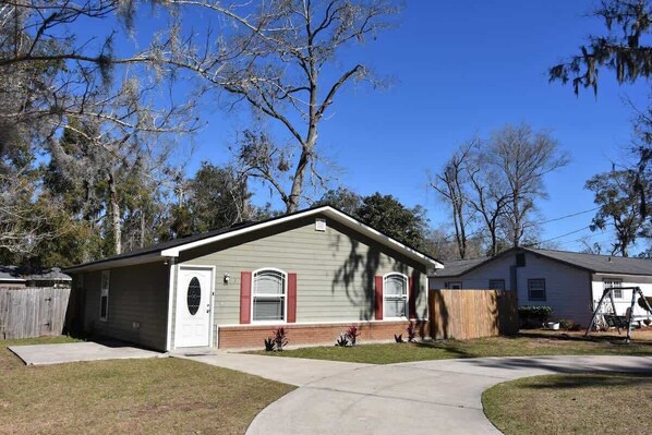 A single-story house with a front porch, a garage, and a small yard.