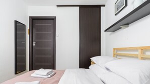 Une chambre d’hôtel avec un lit, une armoire et une étagère sur laquelle est posée une image.