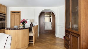 Una cocina con armarios de madera, una isla curva y una zona de estar con sillas.