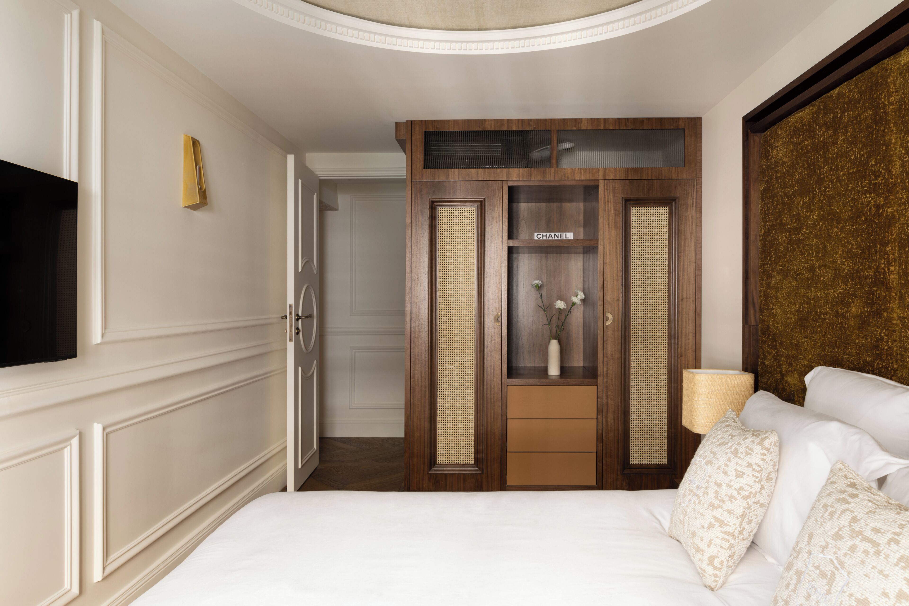 Une chambre d’hôtel avec un lit, une armoire, une télévision et une lampe.