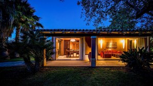 Ein modernes Haus mit einer Terrassenfläche, einem Esszimmer und einem Wohnzimmer mit roten Möbeln.