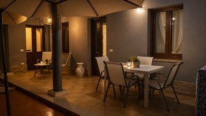 An outdoor patio with a table and chairs, a potted plant, and a lantern. - Donna Giovanna Holiday Home Pula (Pula)