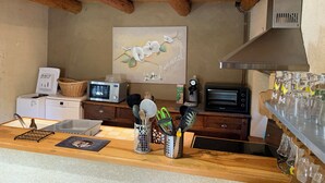 Une cuisine avec des poutres en bois, un four à micro-ondes, un grille-pain et une machine à café sur le plan de travail.