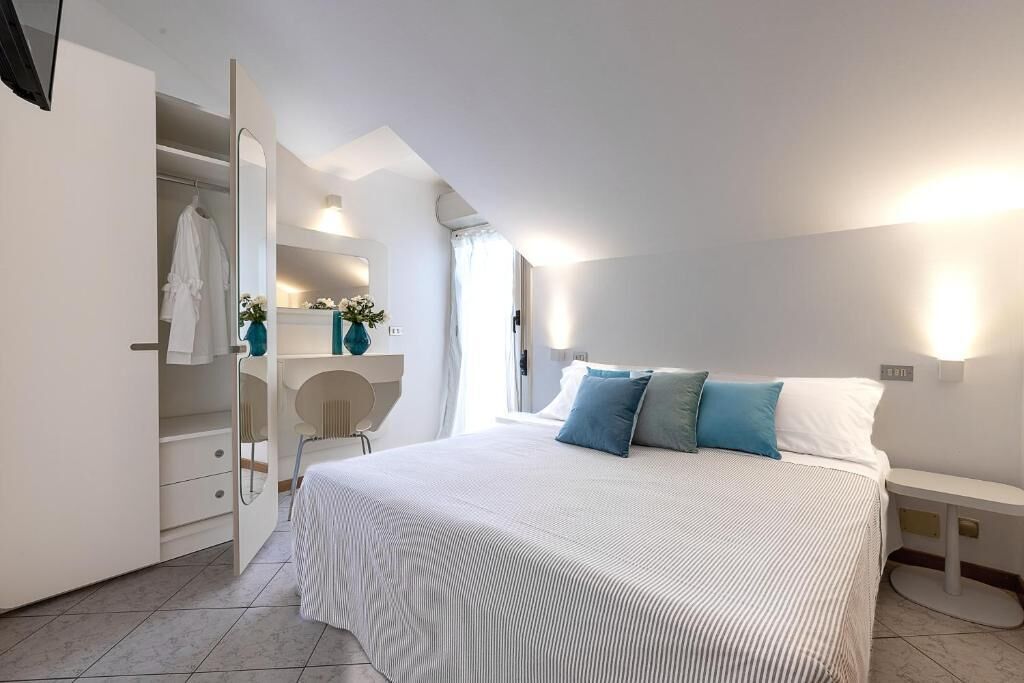 A bedroom with a bed, bedside table, and a wardrobe.