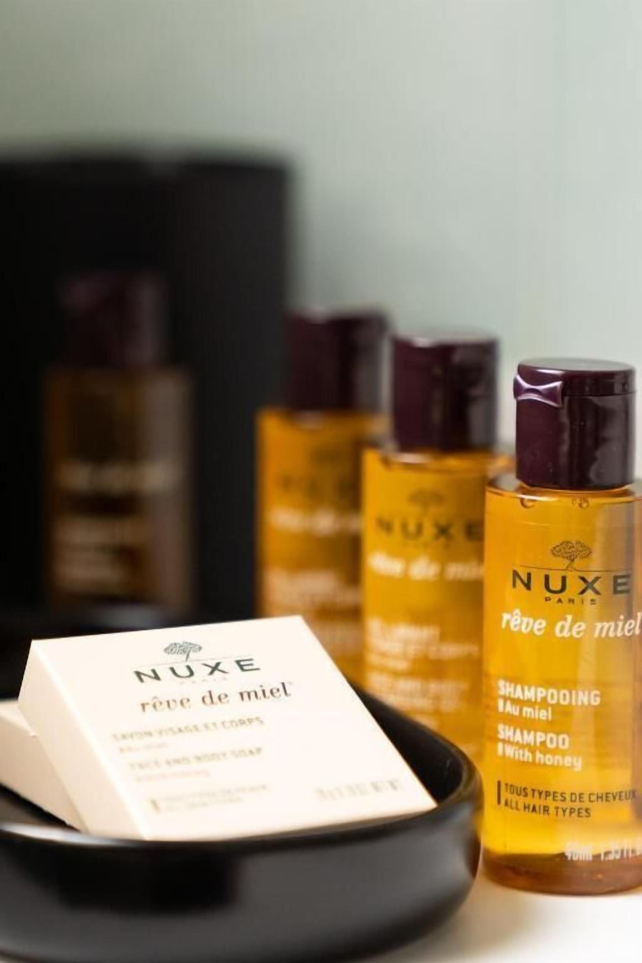 Un conjunto de productos para el cabello de Nuxe, incluyendo champú y gel de ducha.