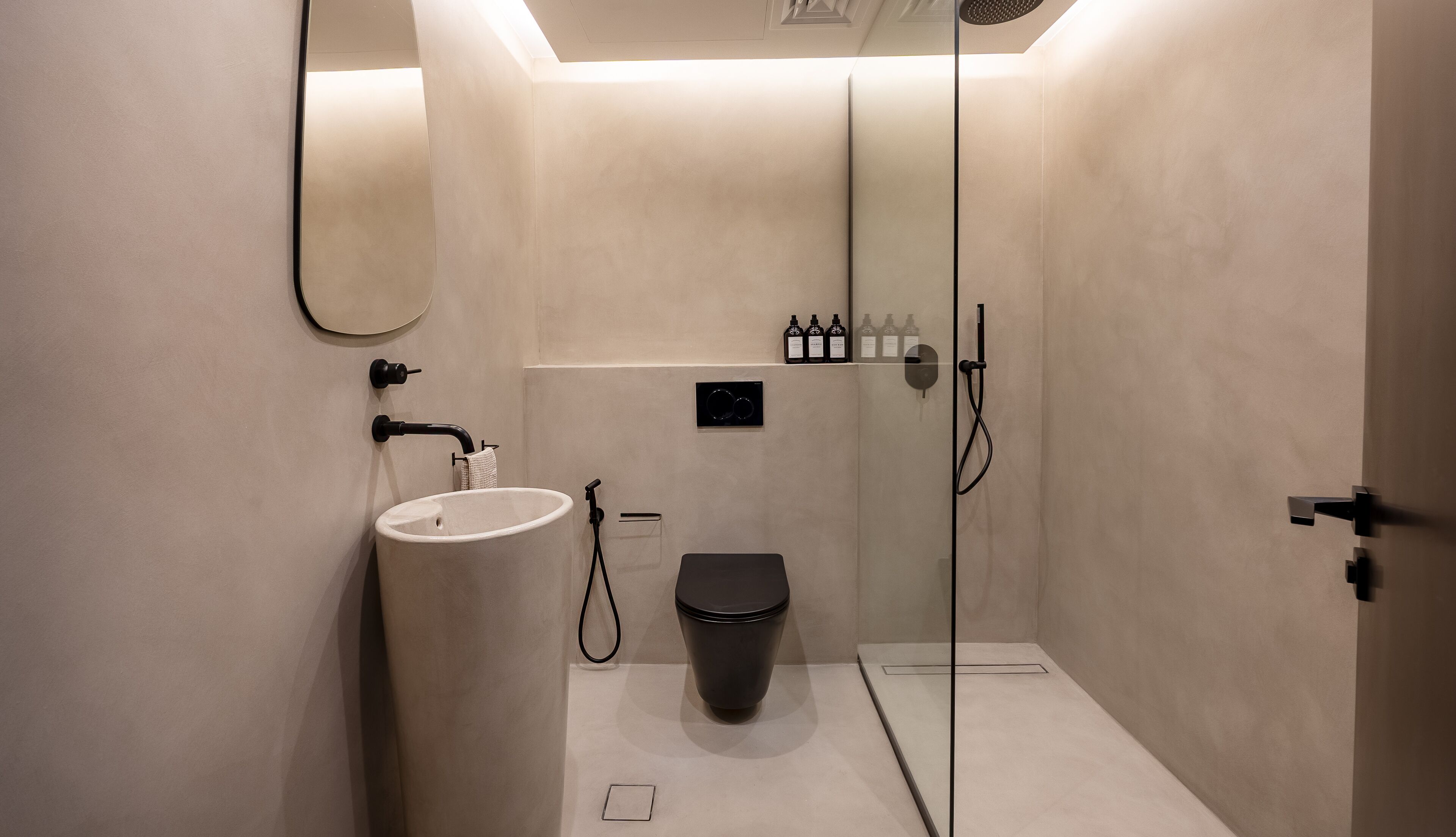 Een moderne badkamer met een wastafel, toilet en douche.