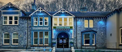 Un edificio de piedra con un cartel que dice "CRAIGSIDE MANOR".