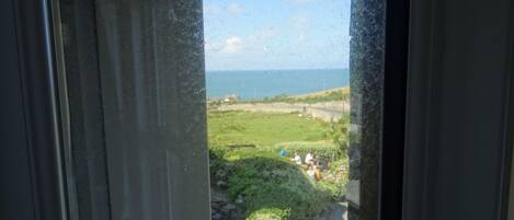 A view through a window with a clear sky and a distant landscape.