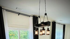 A dining area with a dark wooden table set for six, surrounded by upholstered chairs.