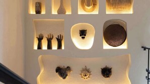 Paret amb diversos objectes il·luminats, com caps d'animals i mans, disposats en un dibuix de quadrícula.