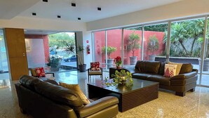 A modern living room with leather sofas, a coffee table, and potted plants. - PENTHOUSE SPECTACULAR VIEW OF THE CITY (Guadalajara)