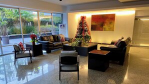 A modern lobby with a glass wall, a Christmas tree, and a large abstract painting. - PENTHOUSE SPECTACULAR VIEW OF THE CITY (Guadalajara)