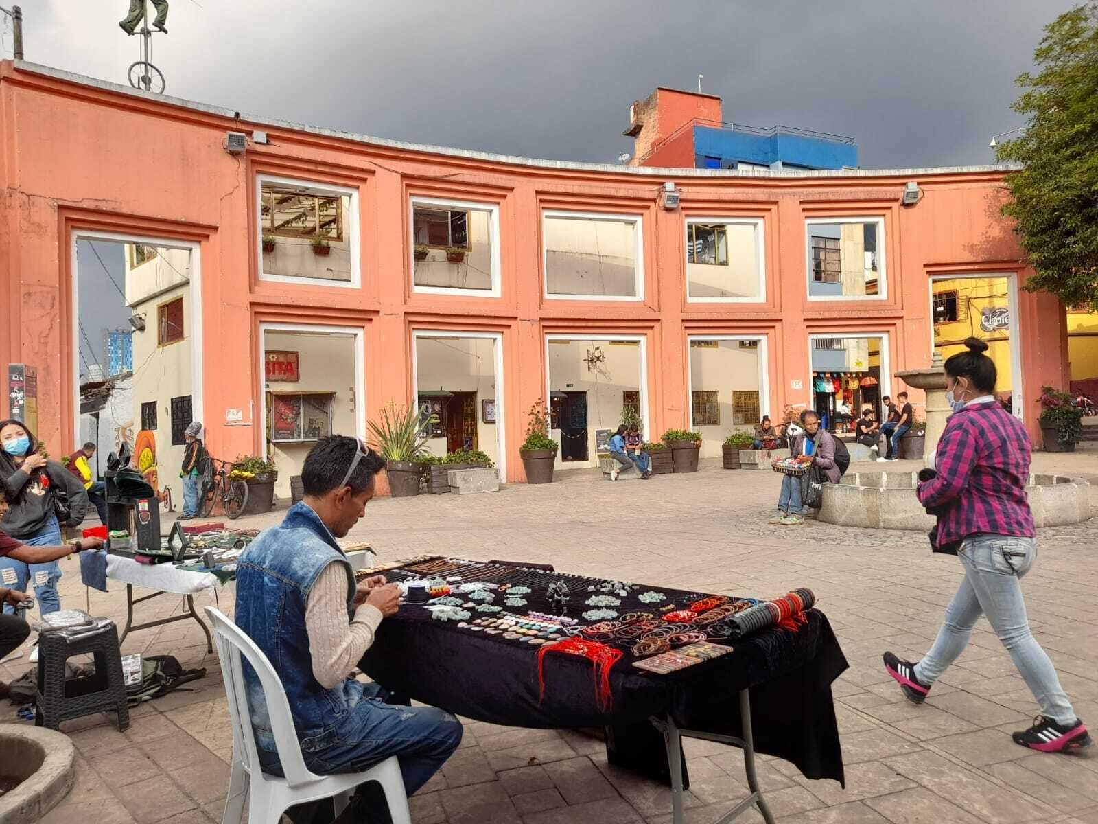 Un marché de rue où un vendeur propose des bijoux sur une table.