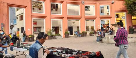 Un marché de rue où un vendeur propose des bijoux sur une table.