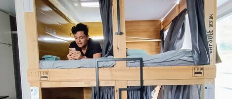 A bunk bed with a sign reading "LAS AGUAS SOCIAL EXPERIENCE" and a checkout sign.