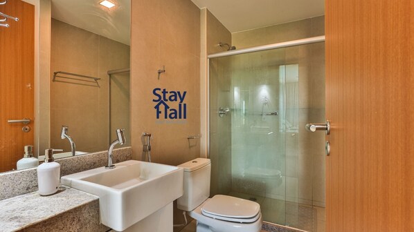A modern bathroom with a sink, toilet, and glass-enclosed shower. - Apt 2QTS-Eco Resort-Cond Beira-Mar-SH036 (Tamandaré)